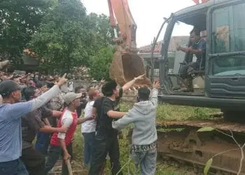 USIR ESKAVATOR : Puluhan warga memaksa ekskavator yang akan digunakan untuk pembebasan lahan pergi dari lokasi, Selasa (11/8). (IRFAN MAULANA/SATELIT NEWS)