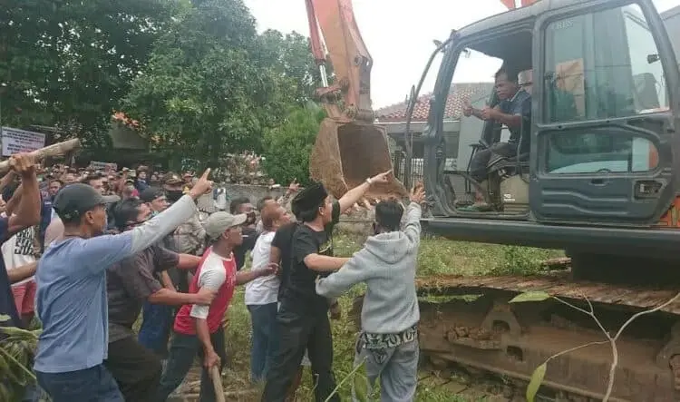 USIR ESKAVATOR : Puluhan warga memaksa ekskavator yang akan digunakan untuk pembebasan lahan pergi dari lokasi, Selasa (11/8). (IRFAN MAULANA/SATELIT NEWS)