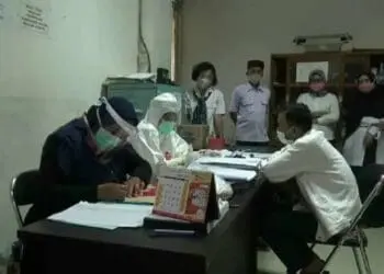 RAPID TES: Petugas medis lengkap dengan APD Covid-19, saat melakukan rapid tes di kantor Disdukcapil Lebak, Rabu (26/8). (MULYANA/SATELIT NEWS)