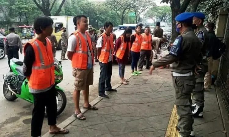 DIHUKUM: Aparat gabungan memberikan sanksi kepada para pelanggar, menghapal Pancasila dan menyanyikan lagu Indonesia Raya. (JARKASIH/SATELIT NEWS)