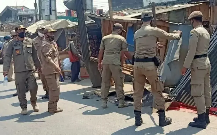 BONGKAR LAPAK: Satpol PP Kabupaten Pandeglang sedang membongkar lapak para PKL di Pasar Labuan, Senin (3/8). Para PKL itu telah direlokasi ke lantai dua Plaza Pasar Labuan. (NIPAL/SATELIT NEWS)