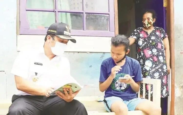 LIHAT BUKU: Walikota Tangerang Arief Wismansyah tampak melihat buku pelajaran dan berbincang dengan salah seorang siswa saat meninjau progres pemasangan fasilitas internet gratis untuk sarana Pembelajaran Jarak Jauh (PJJ) di Kantor Kelurahan Parung Jaya, Kecamatan Karang Tengah, Rabu (12/8). (ISTIMEWA)