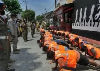 DISANKSI: Puluhan warga yang melanggar PSBB dihukum push up dengan mengenakan rompi pelanggar PSBB. (JARKASIH/SATELIT NEWS)