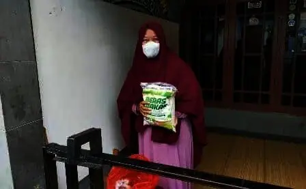 TERIMA BANTUAN: Salah seorang warga saat merima bantuan dari para pemuda. ISTIMEWA