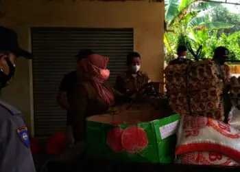 SALURKAN BANTUAN–Kepala Dinsos Pandeglang, Nuriah, didampingi Camat Bojong Endin, dan personel Polsek Bojong, menurunkan bantuan di Kecamatan Bojong, beberapa waktu lalu. (DOKUMEN/SATELITNEWS.ID)
