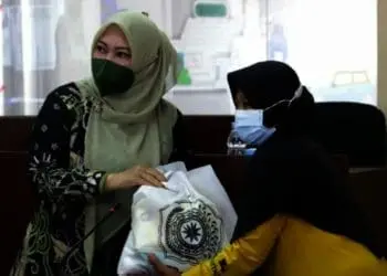 SERAHKAN BANTUAN PAKET SEMBAKO–Secara simbolis, mewakili Ketua TP-PKK Pusat, Tri Tito Karnavian, Bupati Pandeglang, Irna Narulita, menyerahkan bantuan kepada seorang warga yang berhak, di Ruang Pintar Setda Pandeglang, Kamis (8/7/2021). (ISTIMEWA)