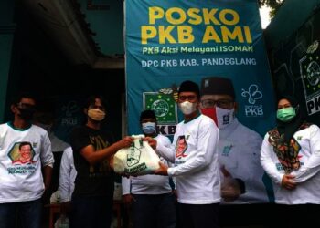 SALURKAN SEMBAKO - Ketua DPC PKB Kabupaten Pandeglang, Nawawi Nurhadi, menyalurkan bantuan paket sembako kepada warga, di posko PKB Aksi Melayani Isoman, Jumat (16/7/2021). (ISTIMEWA)
