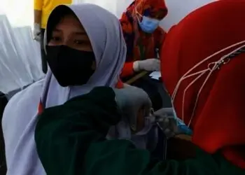 DIVAKSIN–Seorang pelajar, sedang disuntik vaksin oleh tenaga kesehatan di lingkungan Kejari Kabupaten Pandeglang, Selasa (22/7/2021). (NIPAL SUTIANA/SATELITNEWS/ID)