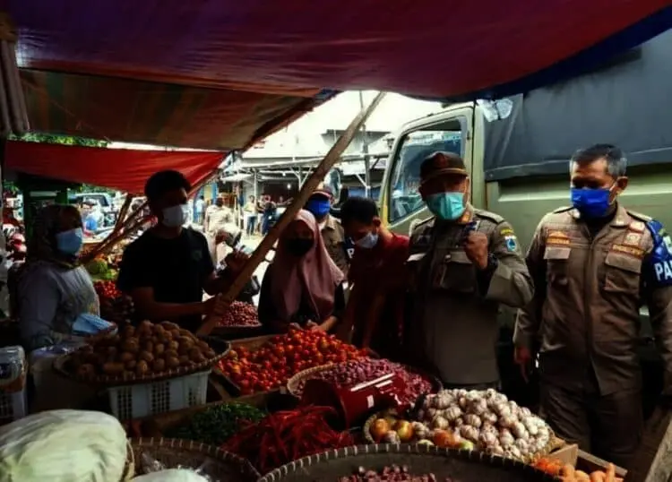 IMBAU MASYARAKAT TERAPKAN PROKES–Kabid Tibumtranmas Satpol PP Pandeglang, Juhanas Waluyo, didampingi jajarannya, sedang memberikan imbauan Prokes kepada para pedagang di pasar Badak Pandeglang, beberapa waktu lalu. (DOKUMEN/SATELITNEWS.ID)