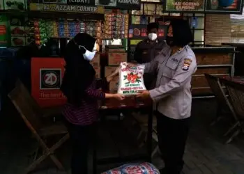 PENYALURAN BANTUAN SEMBAKO–Kabag Logistik Polres Pandeglang, AKP Reni Widowati, memberikan bantuan kepada seorang pedangang Wisata Kuliner Pandeglang Gedung Juang 45 Kabupaten Pandeglang, Senin (2/8/2021). (NIPAL SUTIANA/SATELITNEWS.ID)