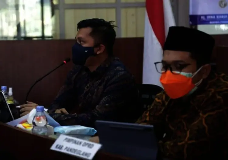 Wabup Pandeglang, Tanto Warsono Arban didampingi Wakil Ketua DPRD Pandeglang, Tubagus Asep Rafiudin Arief, mengenakan peci hitam dan berkacamata, sedang memberikan arahan secara virtual di ruang Pintar Setda Pandeglang, Kamis (12/8/2021). (NIPAL SUTIANA/SATELITNEWS.ID)