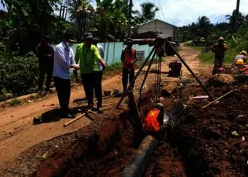 TINJAU LANGSUNG–Dirut PDAM Tirta Berkah Pandeglang, Ujang Sumawinata, didampingi jajarannya, sedang meninjau pengerjaan pemasangan pipa induk jaringan Cikoromoy, Rabu (25/8/2021). (ISTIMEWA)