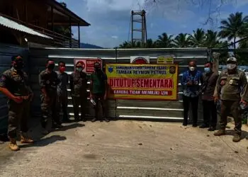 Anggota Satpol PP Pandeglang, sedang menyegel tambak udang yang melanggar Perda RTRW dan Perda Bangunan, di Kecamatan Carita, Kabupaten Pandeglang, menggunakan spanduk besar, Jumat (6/8/2021). (ISTIMEWA)