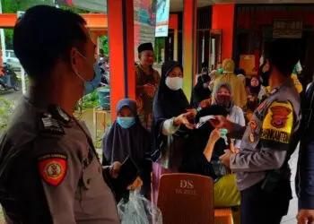 BAGIKAN MASKER–Dalam kesempatan kegiatan vaksinasi, jajaran personel Polsek Pagelaran bagikan masker dan ajak warga terapkan prokes, Jumat (17/9/2021). (ISTIMEWA)
