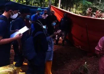 Pihak Polri dibantu oleh masyarakat sedang melakukan proses pembongkaran makam korban miras oplosan di pemakaman umum Kecamat Menes, Selasa (21/9/2021). (ISTIMEWA)