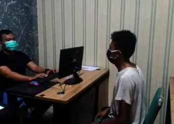 DIPERIKSA–Pengedar narkoba (kanan) yang berhasil dibekuk, sedang diperiksa oleh jajaran Satresnarkoba Polres Pandeglang, di kantornya, Minggu (5/9/2021). (ISTIMEWA)
