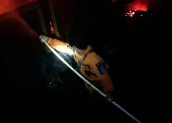Seorang petugas sedang memadamkan kebakaran, Jumat (17/9/2021). (ISTIMEWA)