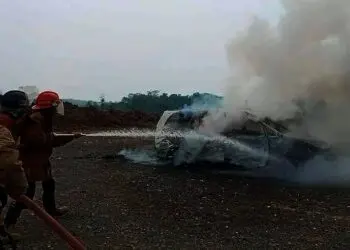 Petugas Damkar sedang memadamkan api yang sempat membakar mobil, akibat dipicu sebuah laptop yang meledak. (ISTIMEWA)