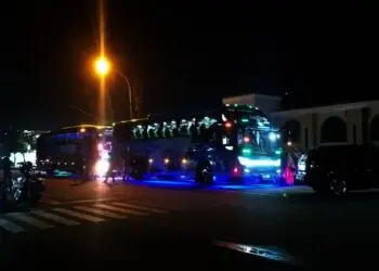 BERANGKAT–Dua unit bus di depan Masjid Agung Ar-Rahman, Rabu (27/10/2021) malam, yang digunakan pegawai Disdukcapil Pandeglang untuk Family Gathering ke Yogyakarta. (NIPAL SUTIANA/SATELITNEWS.ID)