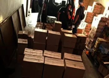 RIBUAN BOTOL MIRAS DISITA–Personel Satreskrim Polres Pandeglang, sedang mengamankan ribuan botol Miras di Mapolres Pandeglang, Rabu (6/10/2021) dini hari. (ISTIMEWA)
