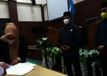 PERSETUJUAN BERSAMA–Disaksikan Pimpinan DPRD Pandeglang, Bupati Pandeglang Irna Narulita, menandatangani persetujuan bersama APBD Pandeglang TA 2022, di Ruang Paripurna DPRD Pandeglang, Rabu (24/11/2021) malam. (NIPAL SUTIANA/SATELITNEWS.ID)
