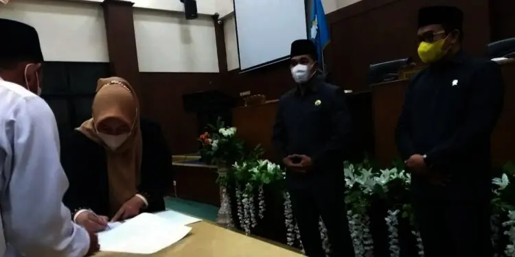 PERSETUJUAN BERSAMA–Disaksikan Pimpinan DPRD Pandeglang, Bupati Pandeglang Irna Narulita, menandatangani persetujuan bersama APBD Pandeglang TA 2022, di Ruang Paripurna DPRD Pandeglang, Rabu (24/11/2021) malam. (NIPAL SUTIANA/SATELITNEWS.ID)