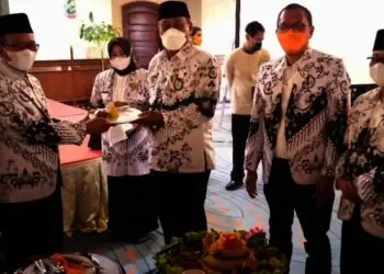 Wakil Bupati Serang Pandji Tirtayasa (kanan), memberikan potongan tumpeng kepada Ketua PGRI Kabupaten Serang (kiri), saat memperingati HUT PGRI di salah satu hotel di Anyer, Kamis (25/11/2021). (ISTIMEWA)