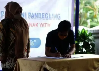 Ketua Porwan Pandeglang, Nipal Sutiana, menandatangani surat tanda terima guna pakai gedung Porwan, disaksikan Bupati Pandeglang Irna Narulita, Kamis (4/11/2021). (MARDIANA/SATELITNEWS.ID)