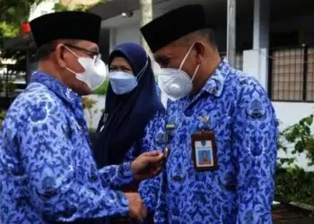 Pj Sekda Pandeglang, Taufik Hidayat, secara simbolis memasangkan lencana kepada pejabat yang berhak, di halaman Setda Pandeglang, Senin (29/11/2021). (ISTIMEWA)
