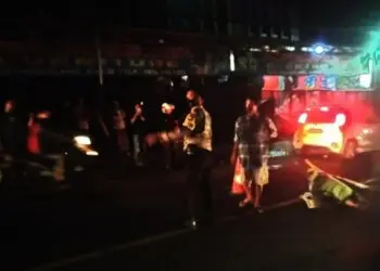 Seorang pengendara yang tewas usai kecelakaan, tergeletak di tengah jalan. Petugas kepolisian dari Polres Serang Kota, langsung turun tangan mengevakuasi korban, Rabu (24/11/2021) malam. (ISTIMEWA)