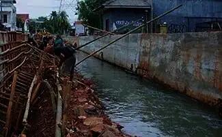 REVITALISASI: Para pekerja sedang melakukan pekerjaan revitalisasi sungai yang melintasi kawasan Reni Jaya Kecamatan Pamulang.