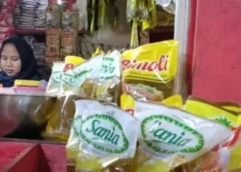 Seorang pedagang di Pasar Badak Pandeglang, sedang menjajakan minyak goreng dan barang dagangan lainnya, Senin (24/1/2022). (NIPAL SUTIANA/SATELITNEWS.ID)