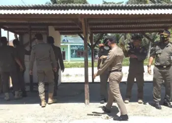 Anggota Satpol PP Kabupaten Serang, memberikan teguran ke seorang pemilik bangunan liar yang berdiri di pinggir saluran irigasi Pamarayan, di Kecamatan Kibin, Kabupaten Serang, Selasa (4/1/2021). (ISTIMEWA)