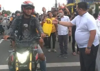 BERBAGI TAKJIL–Ketua PN Pandeglang, Titis Wulandari, didampingi jajarannya memberikan takjil ke pengendara yang melintas di jalan Raya Pandeglang – Serang, Rabu (20/4/2022). (NIPAL SUTIANA/SATELITNEWS.ID)