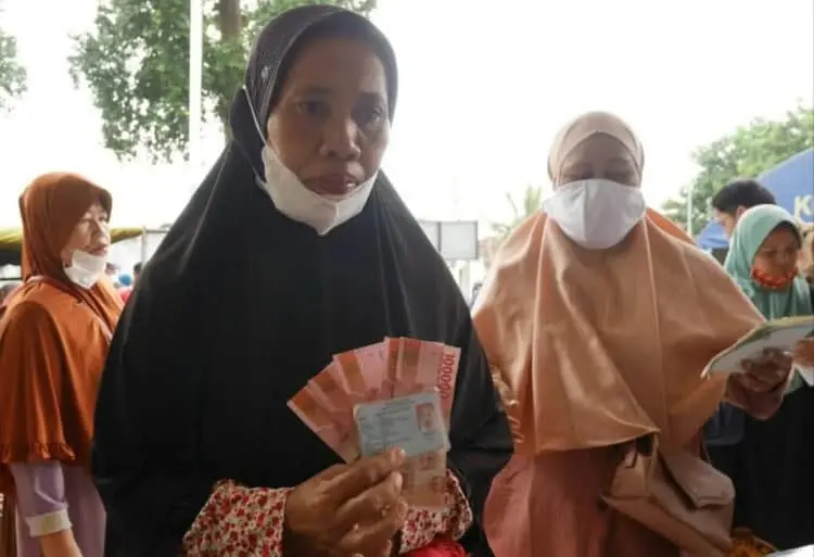 Seorang warga Kecamatan Karangtanjung, Kabupaten Pandeglang, menerima BLT Migor, Kamis (14/4/2022). (ISTIMEWA)