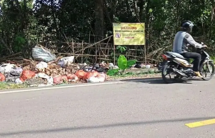 Sampah terlihat menumpuk dan berserakan di pinggir Jalan Raya AMD Lintas Timur Pandeglang, padahal terpangpang papan larangan buang sampah, Senin (16/5/2022). (ISTIMEWA)