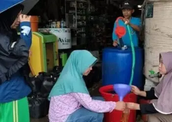 BERBURU MIGOR CURAH–Warga sedang membeli minyak goreng curah, di salah satu pedagang di Pasar Jiput, Kabupaten Pandeglang, Senin (30/5/2022). (ISTIMEWA)