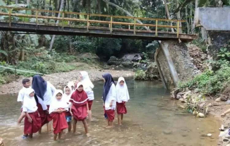 TEROBOS SUNGAI–Siswa SD di Kampung Cegog, sedang menerobos sungai, agar bisa sampai ke sekolah, Rabu (20/7/2022). (ISTIMEWA)