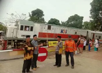 Petugas Dishub Kabupaten Serang, pasang palang perlintasan kereta api, Kamis (28/7/2022). (ISTIMEWA)