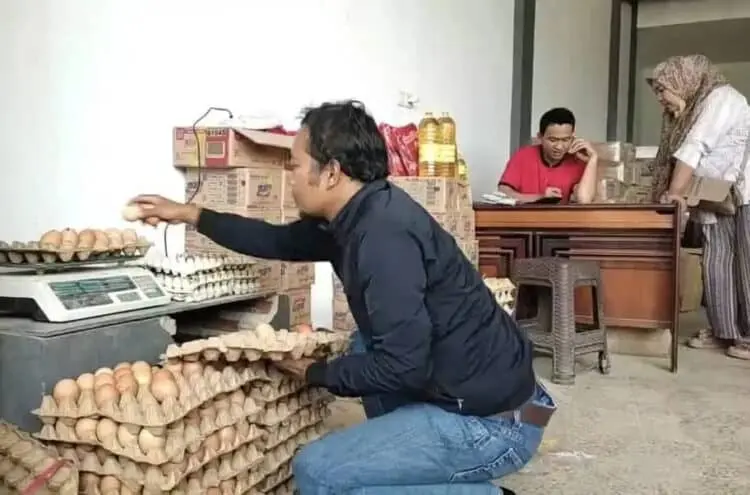 Pembeli telur retak dan pecah, sedang memilah kondisi telur yang bakal dibelinya, Selasa (30/8/2022). (ISTIMEWA)