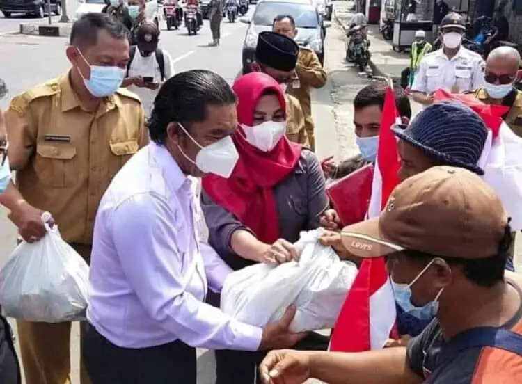 PJ Gubernur Banten, Al Muktabar, membagikan bingkisan bendera merah putih kepada para pelajar, di kawasan gedung Plaza Aspirasi KP3B, Curug, Kota Serang, Selasa (9/8/2022). (ISTIMEWA)