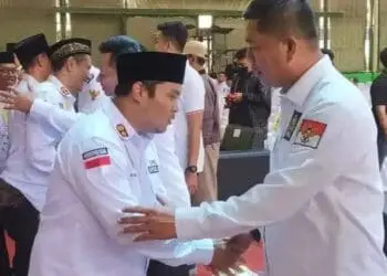 Fahmi Hakim (kanan), sedang berjabatan tangan dengan seorang Kepala Desa, di Kabupaten Serang. (SIDIK/SATELITNEWS.COM)