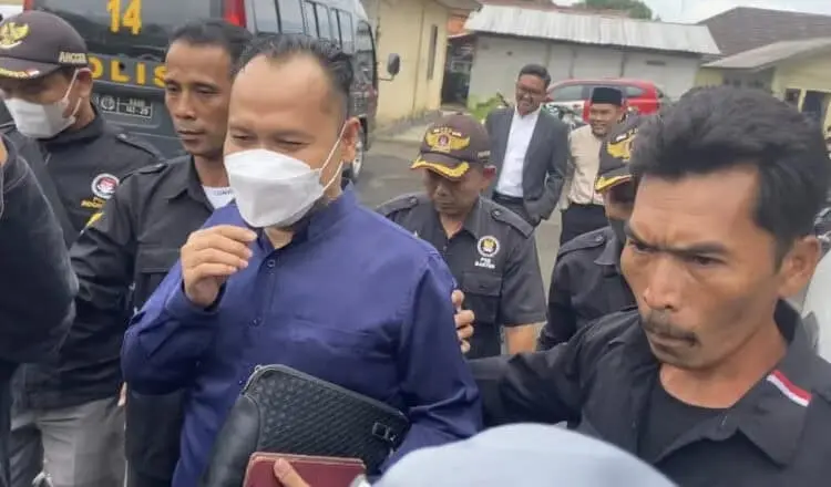Oknum Anggota DPRD Pandeglang berinisial Y (bermasker), keluar dari Mapolres Pandeglang pasca diperiksa penyidik di Mapolres setempat, Selasa (20/12/2022). (NIPAL SUTIANA/SATELITNEWS.COM)