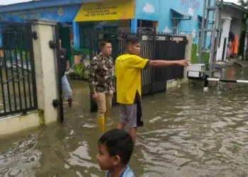 Camat Kibin, Babay Karnawi, melakukan pengecekan kondisi banjir yang merendam rumah warga. (SIDIK/SATELITNEWS.COM)