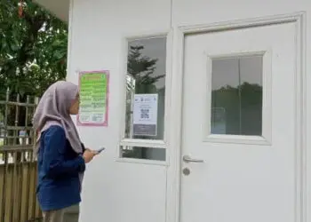 KANTOR: Situasi di depan kantor MUI Kabupaten Tangerang, Rabu (3/5). Terlihat salah satu pengunjung sedang melakukan scan barcode yang terpasang di depan kantor. (ALFIAN HERIANTO/SATELIT NEWS)