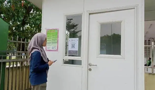 KANTOR: Situasi di depan kantor MUI Kabupaten Tangerang, Rabu (3/5). Terlihat salah satu pengunjung sedang melakukan scan barcode yang terpasang di depan kantor. (ALFIAN HERIANTO/SATELIT NEWS)