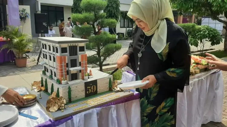 POTONG KUE: Direktur Utama RSUD Kabupaten Tangerang, Reniati terlihat sedang memotong kue ulang tahun yang berbentuk gedung RSUD Kabupaten Tangeranng, Rabu (17/5). (ALFIAN HERIANTO/SATELIT NEWS)