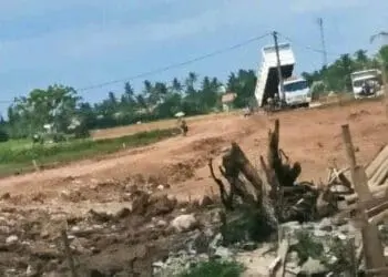 MENURUNKAN TANAH: Suasana di proyek pengurukan tanah di Kampung Pondok Kelor, Desa Pondok Kelor, Kecamatan Sepatan Timur, Minggu (21/5). Terlihat sebuah mobil kendaraan besar sedang menurunkan tanah. (ALFIAN HERIANTO/ SATELIT NEWS)