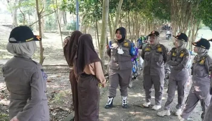 EDUKASI: Prajawati Kabupaten Tangerang dan Tim Reaksi Cepat (TRC) saat memberikan edukasi kepada dua siswi yang asyik nongkrong saat jam sekolah di tapi danau Puspemkab Tangerang, Tigaraksa, Kamis (22/6/2023). (ISTIMEWA)