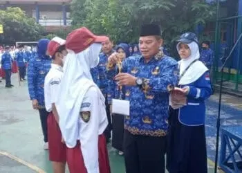 PENYERAHAN ID: Kepala Disdik Kota Tangerang Jamaluddin memakaikan kalung id kepada perwakilan siswa SMPN 16 Kota Tangerang dan SMPN 34 Kota Tangerang sebagai tanda dimulainya MPLS. MADE/SATELIT NEWS.COM